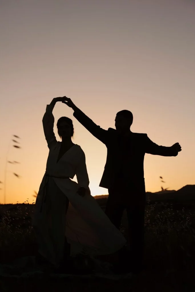 full-shot-couple-silhouettes-dancing-nature_23-2149609658